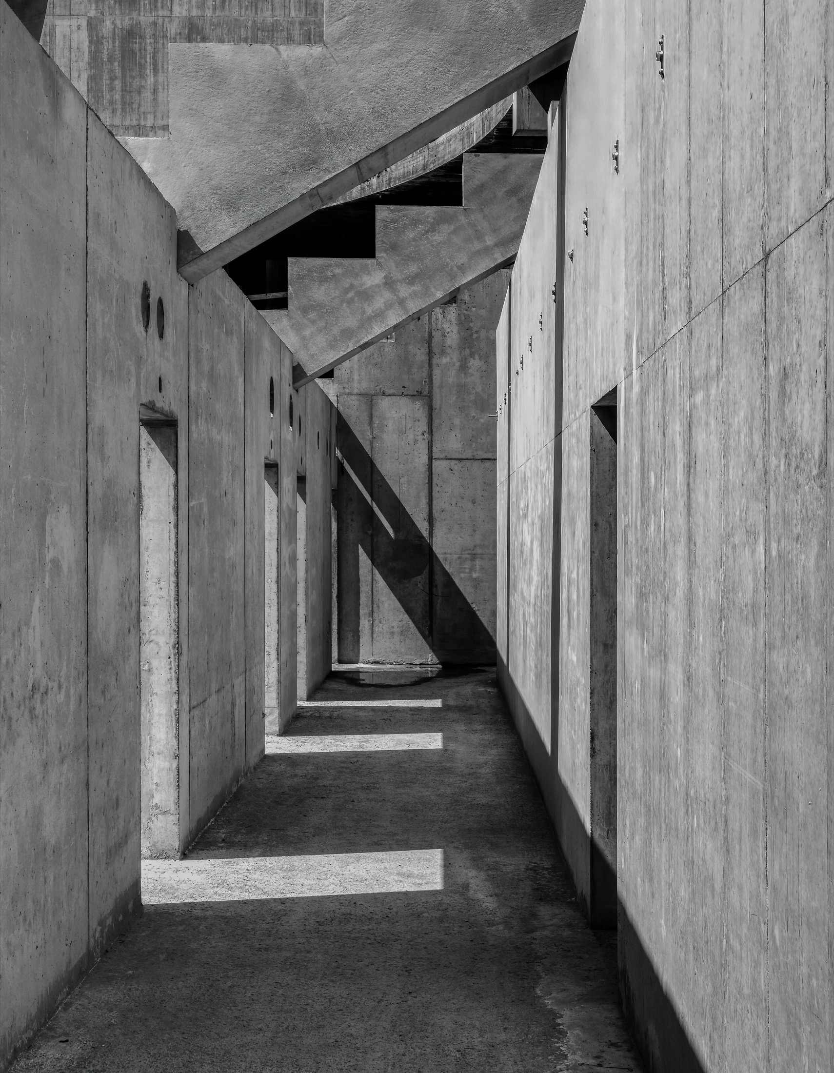 Monochrome concrete corridor with intersecting structural planes